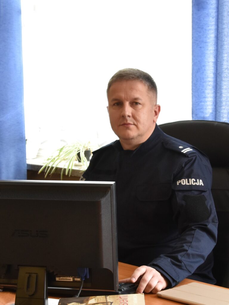 Zdjęcie mężczyzny za biurkiem w mundurze policji