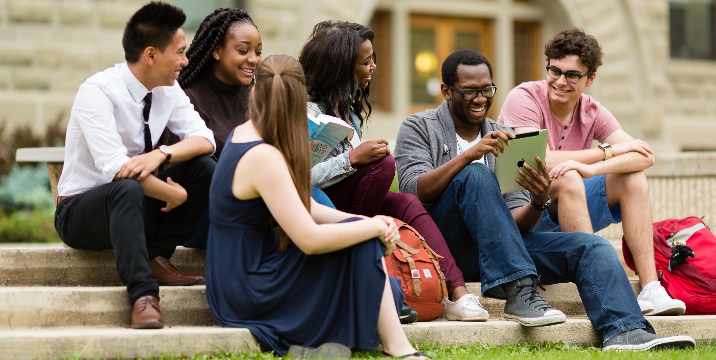 A group of international students sitting on stairs