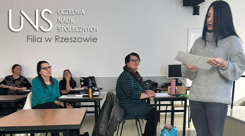 Grupa studentów podczas zajęć, jedna studenta stoi i prezentuje siebie