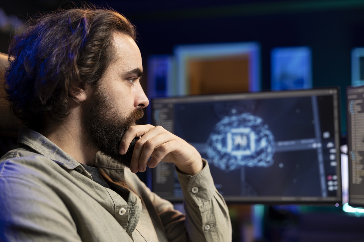 Zdjęcie mężczyzny siedzącego przed monitorami
